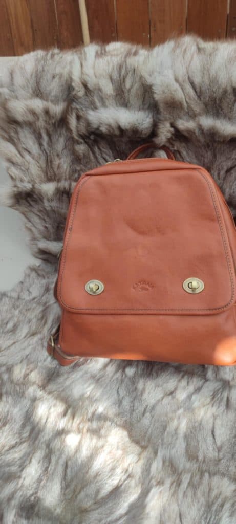 Authentic cuir tanné à la main avec sac à dos en cuir orange sur tapis en fourrure naturelle.