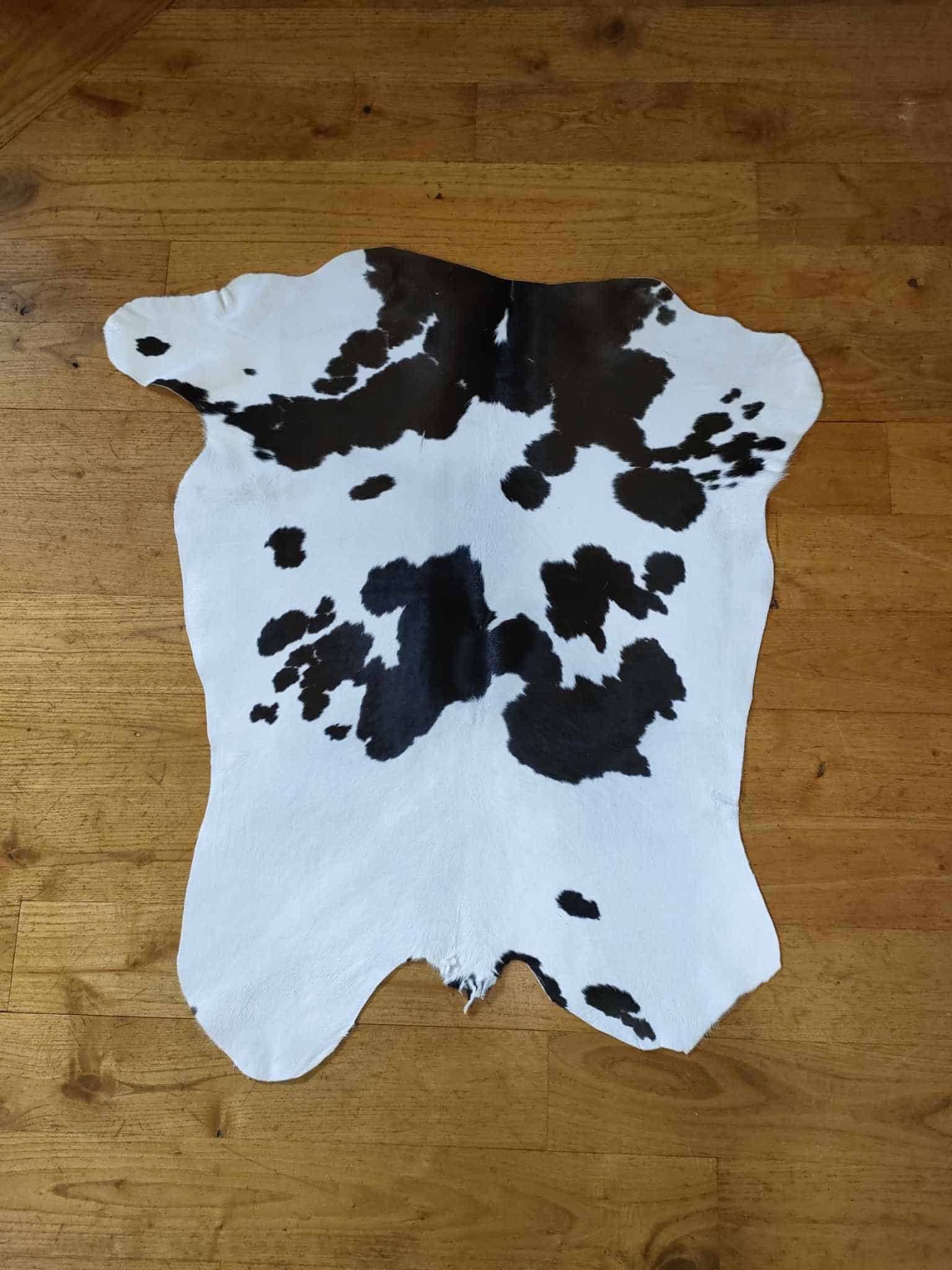 Tapis en peau de vache noire et blanche, décoration intérieure authentique, artisanal et élégant, idéal pour un salon ou une chambre, fabriqué à la main, pièce unique.